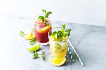 Home made Apple-Lemon and Raspberry-Lemon Lemonade with mint leaves and ice. Summer fruit drinks. Copy space