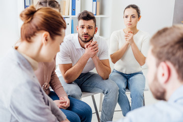 Fototapeta premium people sitting on chairs and having group therapy meeting