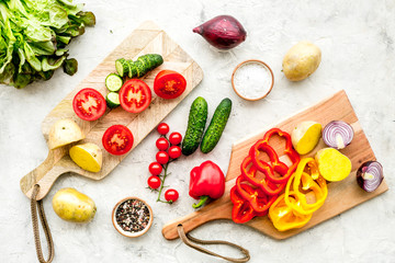 cooking with raw vegetables on light background top view
