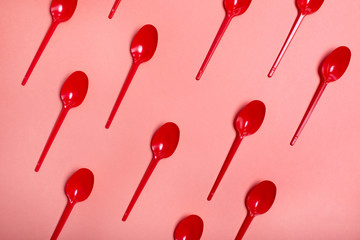 red spoons on coral color background