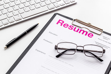 Create CV concept with pen, glasses, keyboard on white desk top view