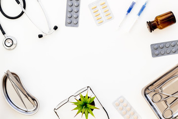 Pills and instruments of doctor frame on white background top view copyspace