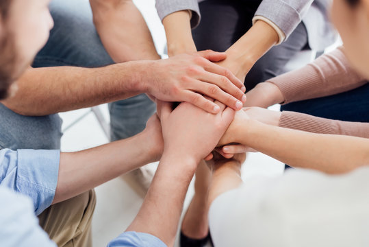 cropped view of people stacking hands during group therapy session © LIGHTFIELD STUDIOS