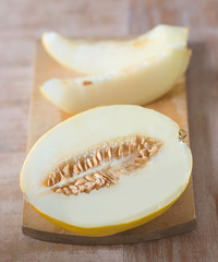 cuted raw melon on wooden board on wooden table