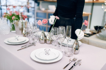 Waitress against empty tableware, table setting