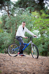 Fototapeta premium A man with a bicycle in the forest, active rest, healthy lifestyle