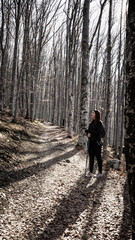 Obraz premium Lonely Hiker Girl hiking in the forest with a stick