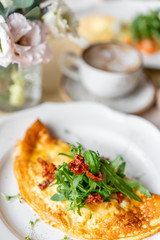 Breakfast. Frittata - italian omelet. Omelette with tomatoes, arugula and soft cheese. Coffee and other dishes on the table in the restaurant
