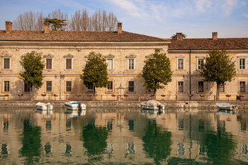 Scenic view of a canal with moored boats and water reflections, Peschiera del Garda, Veneto, Italy