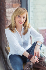 Attractive mid adult woman sitting by the window