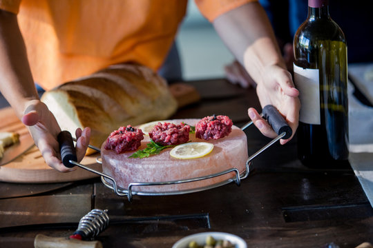 Midsection of woman serving food on wooden table