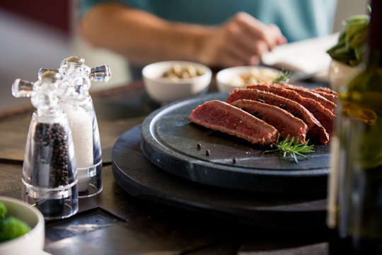 Meat slices served on plate with salt and pepper shakers