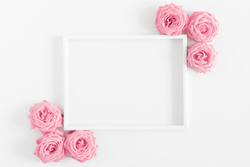 Beautiful flowers composition. Blank frame for text, pink rose flowers on white background. Valentines Day, Easter, Birthday, Happy Women's Day, Mother's day. Flat lay, top view, copy space