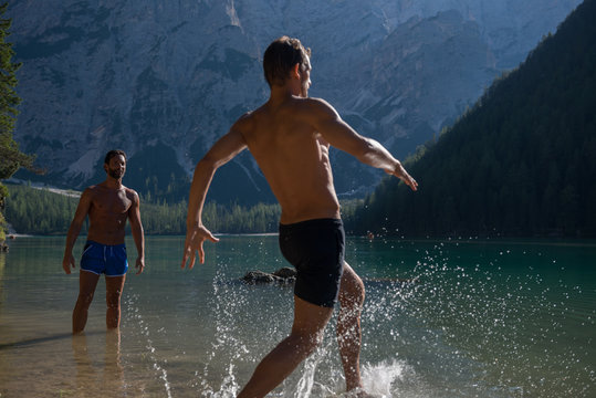 Man running into lake against mountain