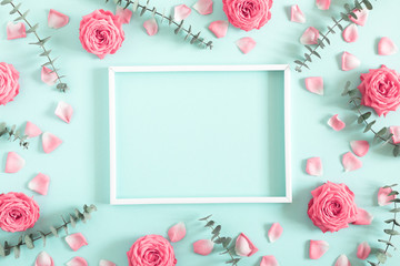 Beautiful flowers composition. Blank frame for text, pink rose flowers, eucalyptus leaves on pastel...