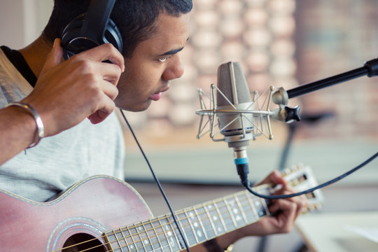 Man with guitar sitting in studio
