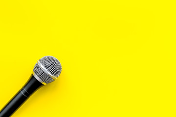 microphone for blogger, journalist or musician work on yellow background top view mock-up
