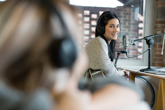 Portrait of smiling young woman sitting in studio