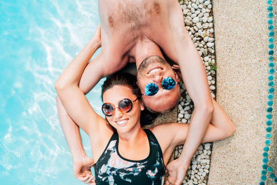 Happy couple in love lying on the pool edge