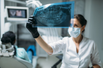 Fototapeta na wymiar Dentist looking on x-ray picture, dental clinic
