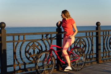 Fototapeta premium Women with a vintage bicycle on a background of the sea