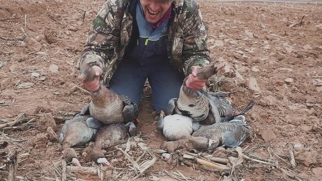 Portrait of a hunter with dead geese. Extraction. Goose Hunter. hunting trophy