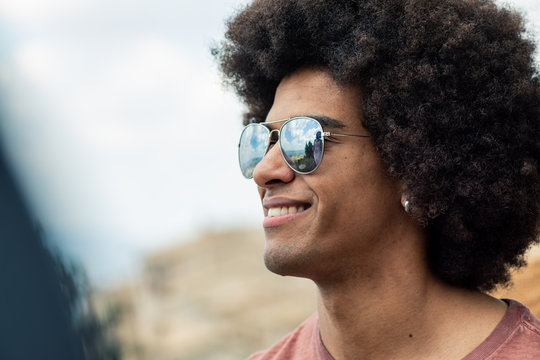 Close up of smiling afro young man standing outdoors