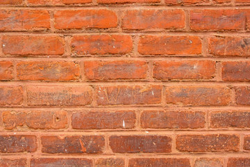 Photo of old red brick wall with imperfections for background.