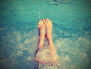 feet of young woman during the whirlpool therapy with old toned