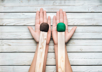 Two big matches in the hands of a girl on a wooden white background. Concept and photography....