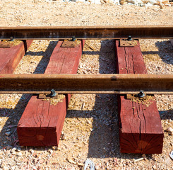 Bolted butt of rails and wooden sleepers laid on groundwork crushed stone. Railway industry and transport infrastructure