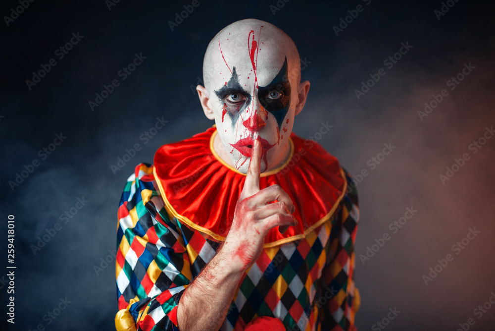 Wall mural portrait of mad bloody clown shows the quiet sign