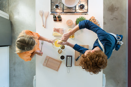 Overhead view of couple preparing food in kitchen