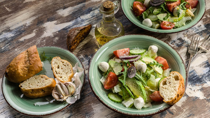 Fototapeta na wymiar Food banner. Italian vegetable salad with avocado, cherry tomatoes, arugula and mozzarella cheese. Delicious and healthy food. Mediterranean Kitchen