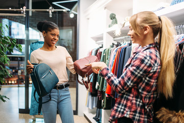 Two females choosing bags in shop, shopping
