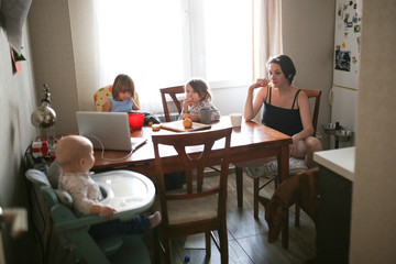 Obraz premium Mom with children and dog in real kitchen