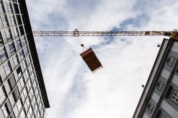 Obraz premium Construction container in the air between buildings in the city
