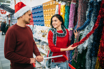 Young couple choosing holiday fluffy garland