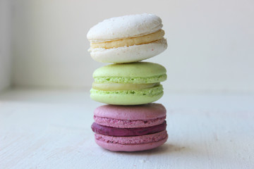 Fototapeta na wymiar Colorful French or Italian macaroon stack cakes / Macaroon cakes. Assorted macaroon cakes stacked on top of each other on a light background. Copy space. Delicious dessert.