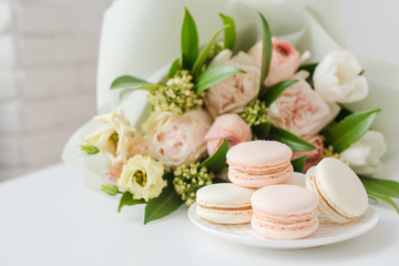 Elegant sweet macarons and pastel colored beige flowers