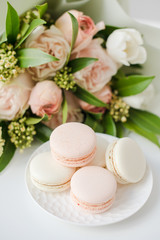 Fototapeta na wymiar Elegant sweet macarons and pastel colored beige flowers