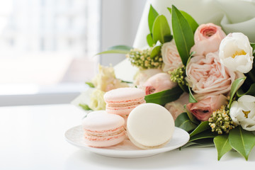 Elegant sweet macarons and pastel colored beige flowers