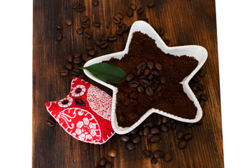 Brown arabica coffee beans with owl on a wooden board.