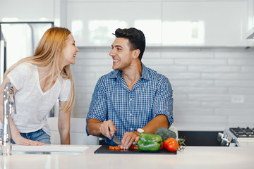 Man in a kitchen. A handsome man with woman at home. Male and famale at home with vagatables....