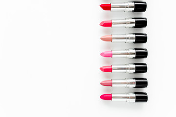 Naklejka premium Set of color lipsticks on white background. Professional decorative cosmetics, promotional product pomade for advertising. Flat composition beauty, fashion. flat lay, top view