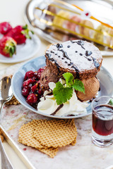 Fresh chocolate ice cream with brownie and cherry jam