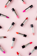 Obraz premium Set of color lipsticks on pink background. Professional decorative cosmetics, promotional product pomade for advertising. Flat composition beauty, fashion. flat lay, top view