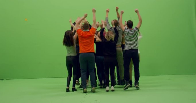GREEN SCREEN CHROMA KEY Back view group of young people dancing and jumping with hands in the air. 4K UHD ProRes 4444