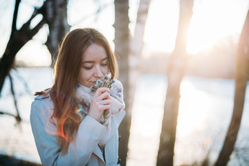 Portrait of a girl with willow branches in early spring at sunset.