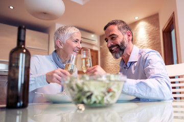 Romantic mature couple enjoying  lunch at home